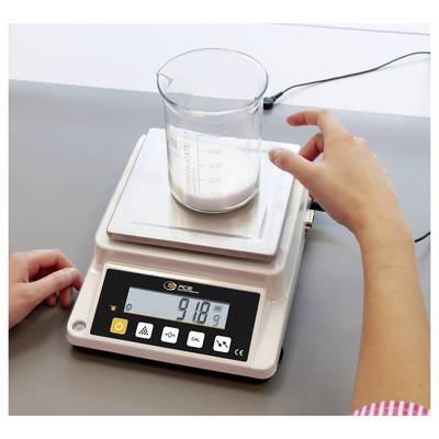 Person uses a digital lab scale to weigh a beaker containing white powder, with the display reading 91.8 g.