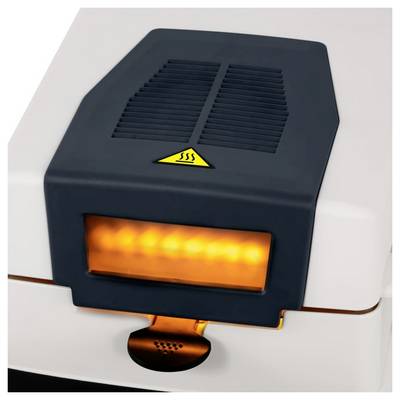 Small black portable heater with glowing orange front panel and heat warning symbol on top, sitting on a white surface.