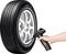 A tyre with 'All-Season' printed on it, alongside a hand placing a digital tyre pressure gauge against the valve.