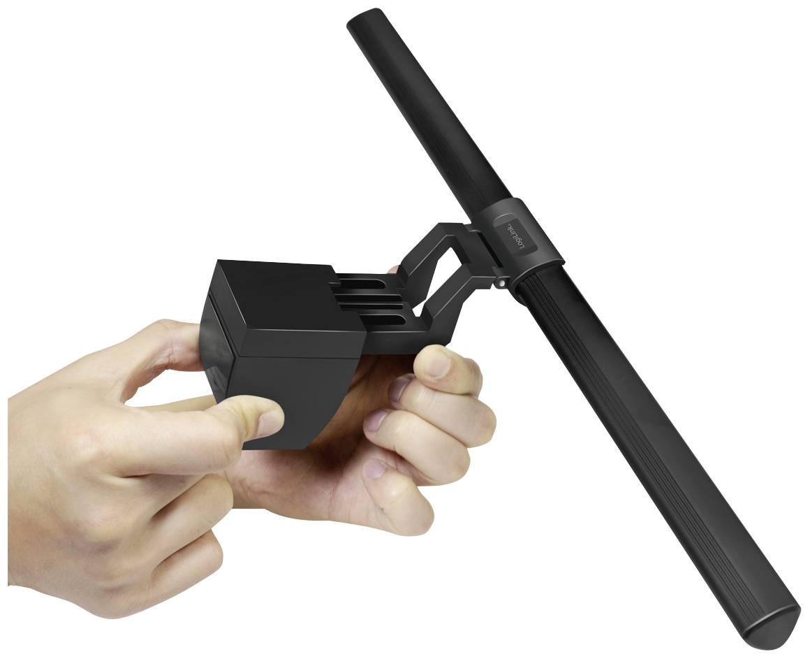 A person is holding a black, elongated lamp with a switch. The lamp has a modern design and is operated with two fingers.