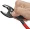 A hand is holding a red pliers with a black handle. The pliers are open, revealing serrated gripping jaws.