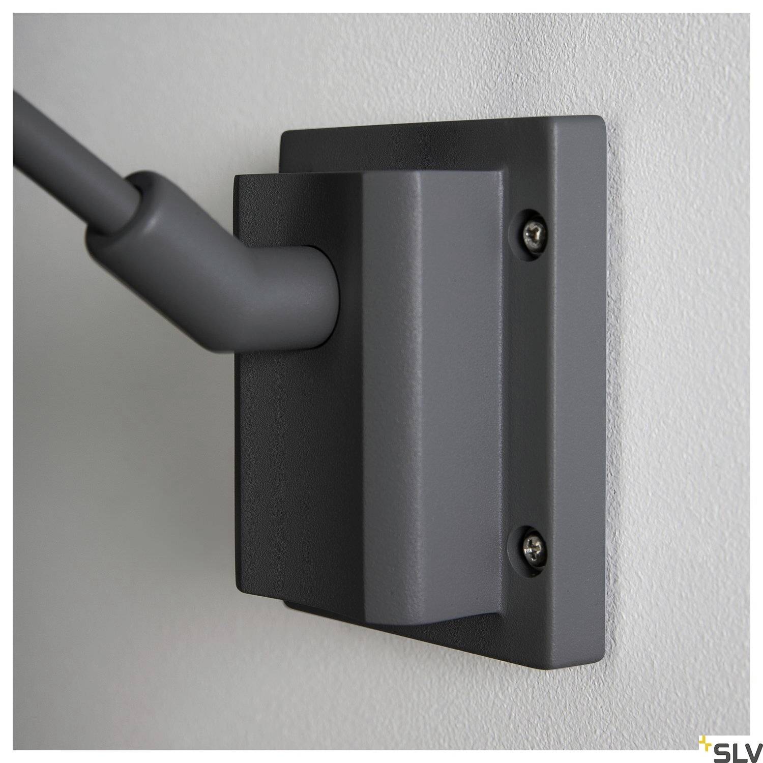 View of a grey wall mount with two screws on a wall. An arm is attached to the mounting bracket.