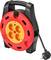 Portable cable reel with four power sockets and a carry handle. It has a red and yellow design. A black cable is plugged in.
