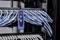 Server rack with connected blue and white Ethernet cables and a cable tester hanging on the cable harness with illuminated indicators.
