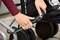 A person is securing a pushchair with a combination lock to ensure safety.
