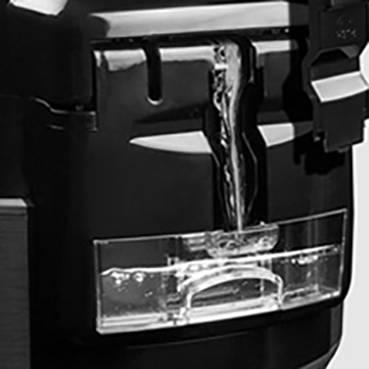 A water dispenser is filling a transparent glass.