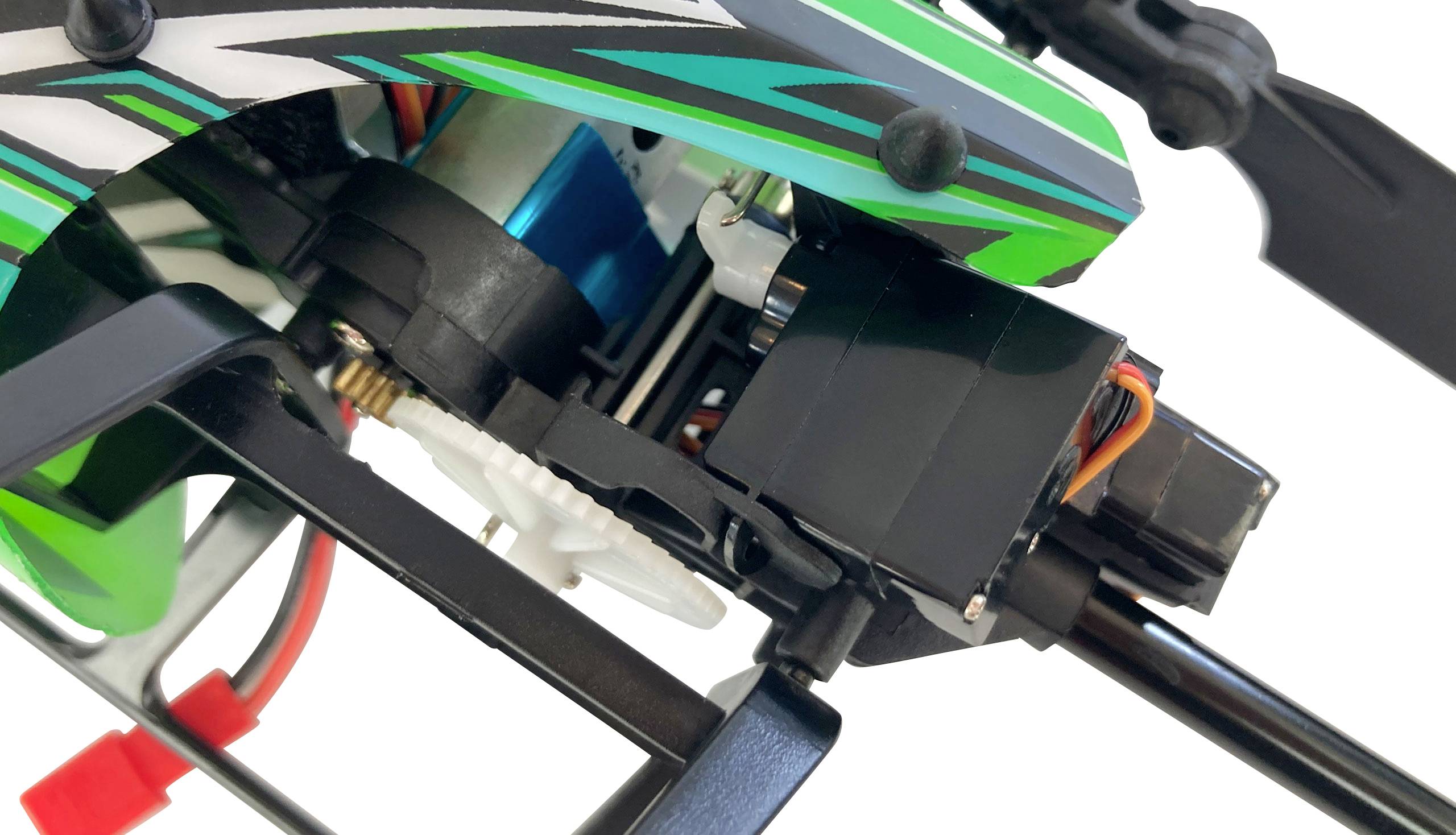 Close-up of a model helicopter with green and black design. Visible gears and wiring revealing technical details.