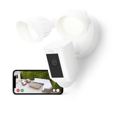 A white surveillance camera with two lights, connected to a smartphone displaying an image of a patio.