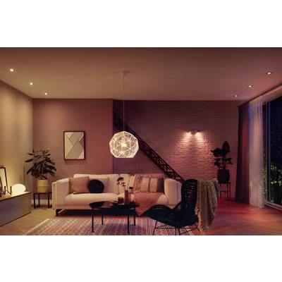 A cosy living room with a white sofa, modern lighting, plants, and wall decorations. Atmospherically lit.