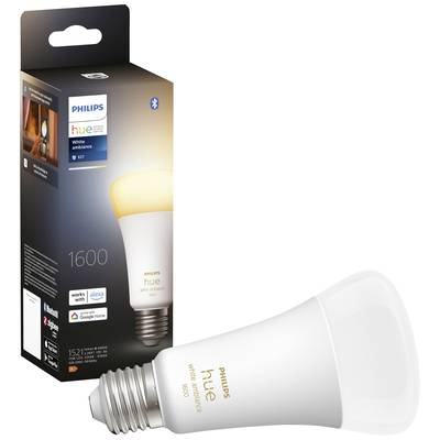 A Philips Hue LED light bulb sits in front of its packaging, which indicates Bluetooth and voice assistant compatibility.