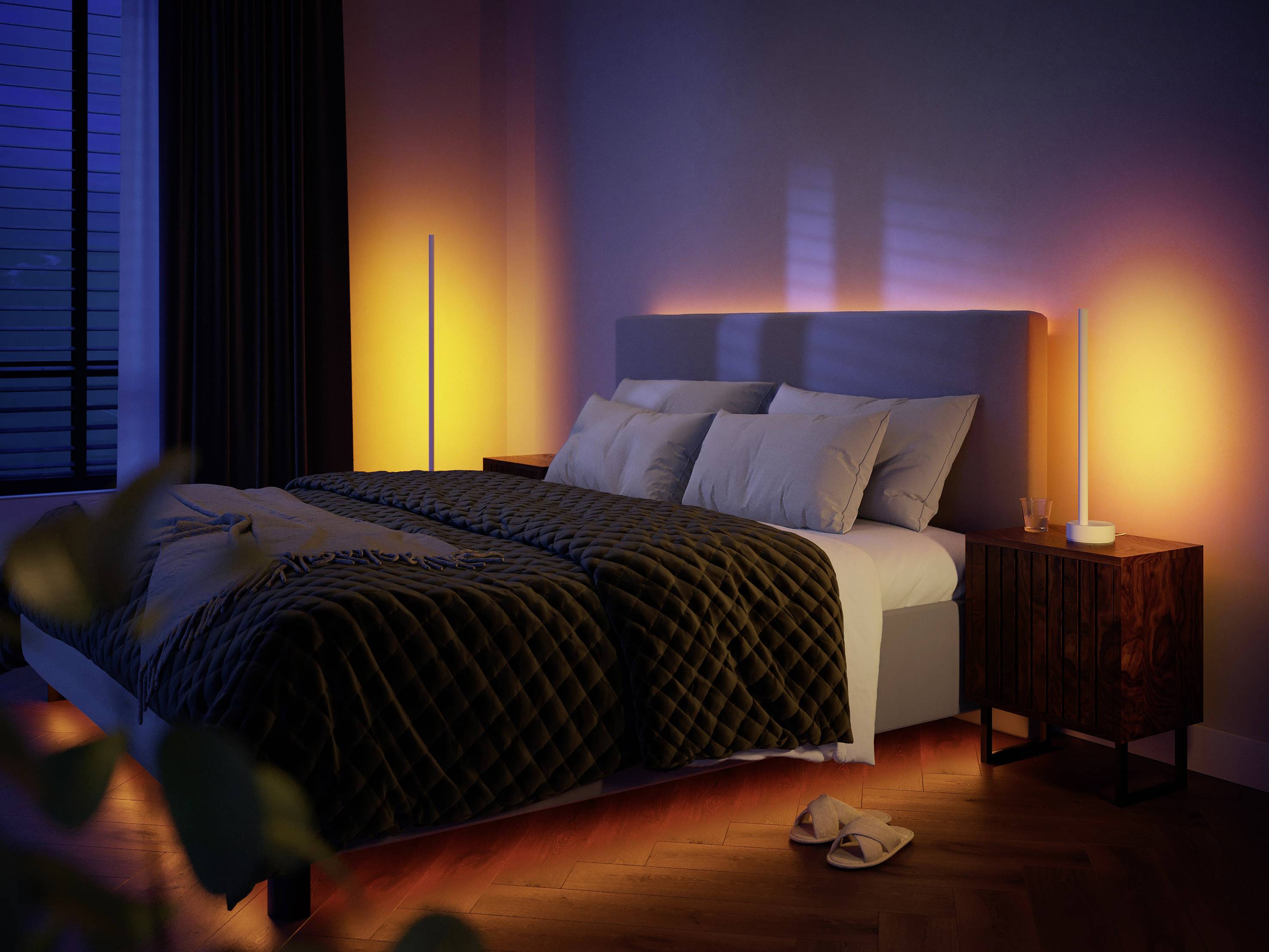 Cosily lit bedroom with a modern double bed, soft bedding, and atmospheric lighting in warm tones.