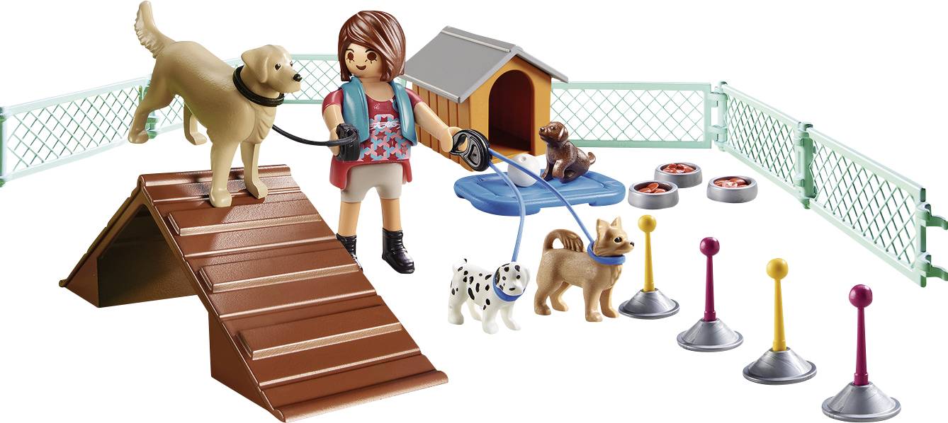 Toy figure trains three dogs in a fenced area with obstacles and a kennel.