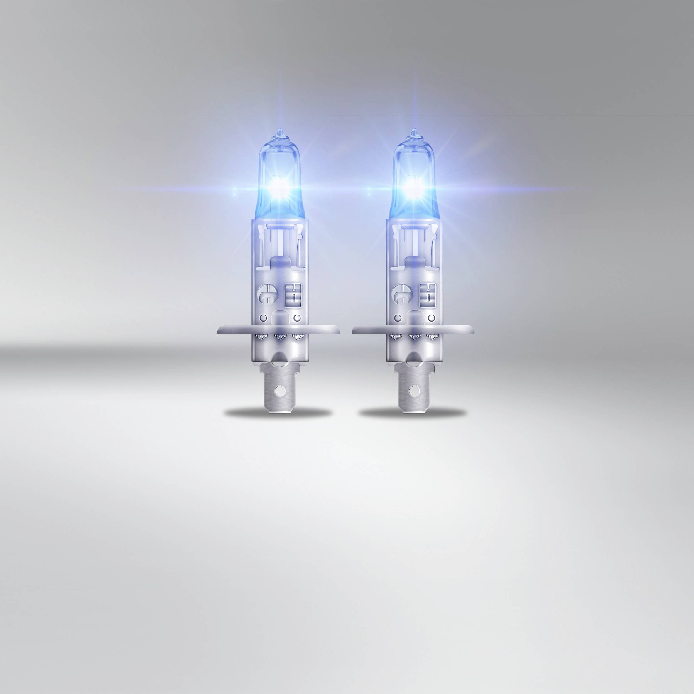 Two luminous halogen lamps on a grey background, arranged symmetrically. They emit a radiant blue-white light.