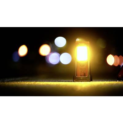 A yellow warning light illuminates on a dark road, surrounded by blurred lights in the background. Safety notice at night.