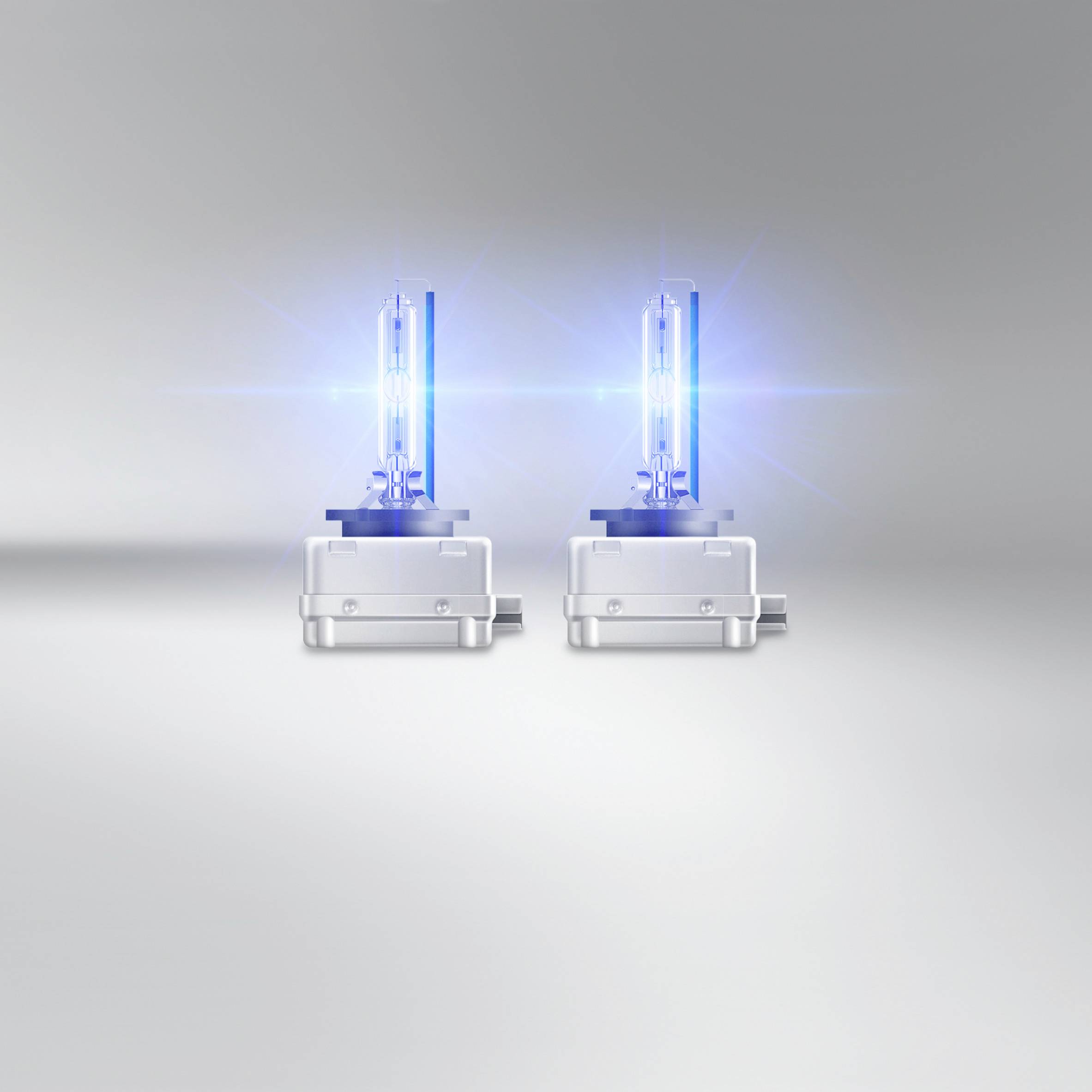 Two blue xenon lamps with modern technology on a grey background; symbolising brightness and energy efficiency.