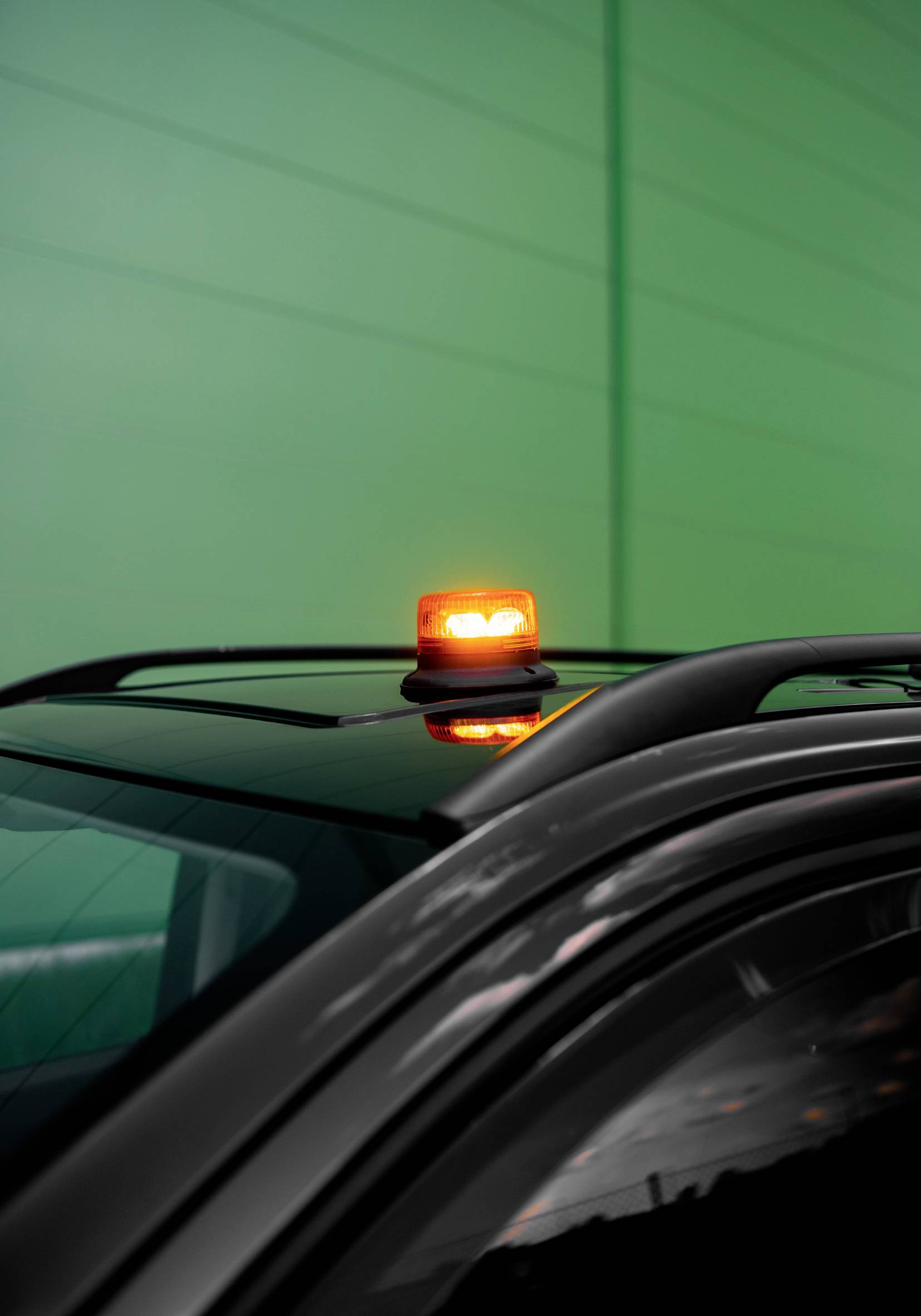 A vehicle with an orange warning light on the roof, blocked.