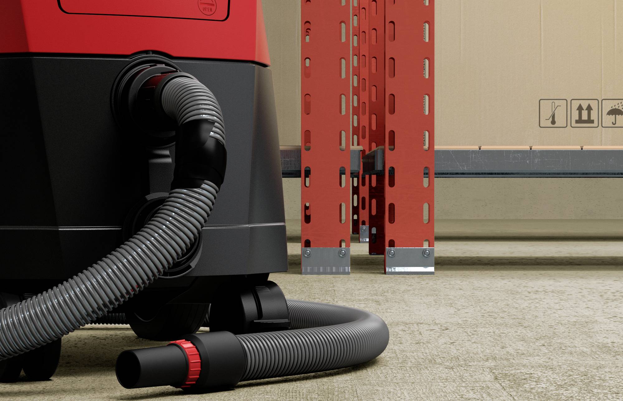 Industrial vacuum cleaner on a concrete floor, with a shelving system and a cardboard box with caution and handling symbols in the background.