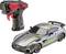 Toy car in silver with green stripes next to a black and red remote control, suitable for racing simulations.