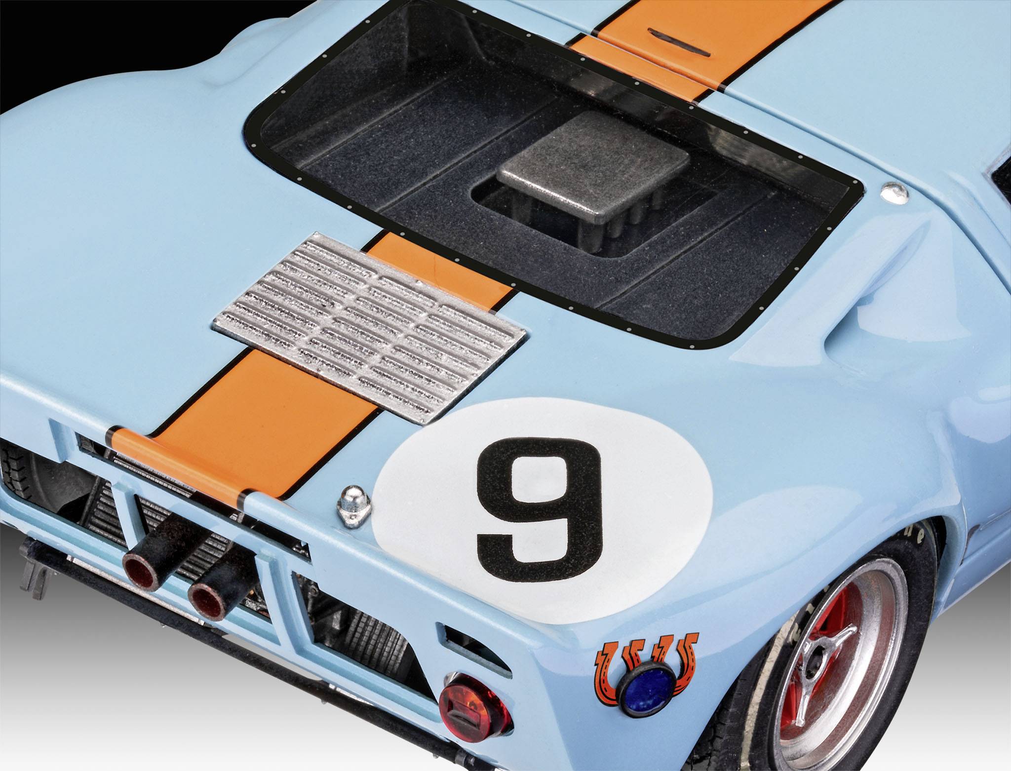 Close-up of a blue racing car with orange stripes and the number 9 on the back. Views of ventilation grilles and exhaust pipes.