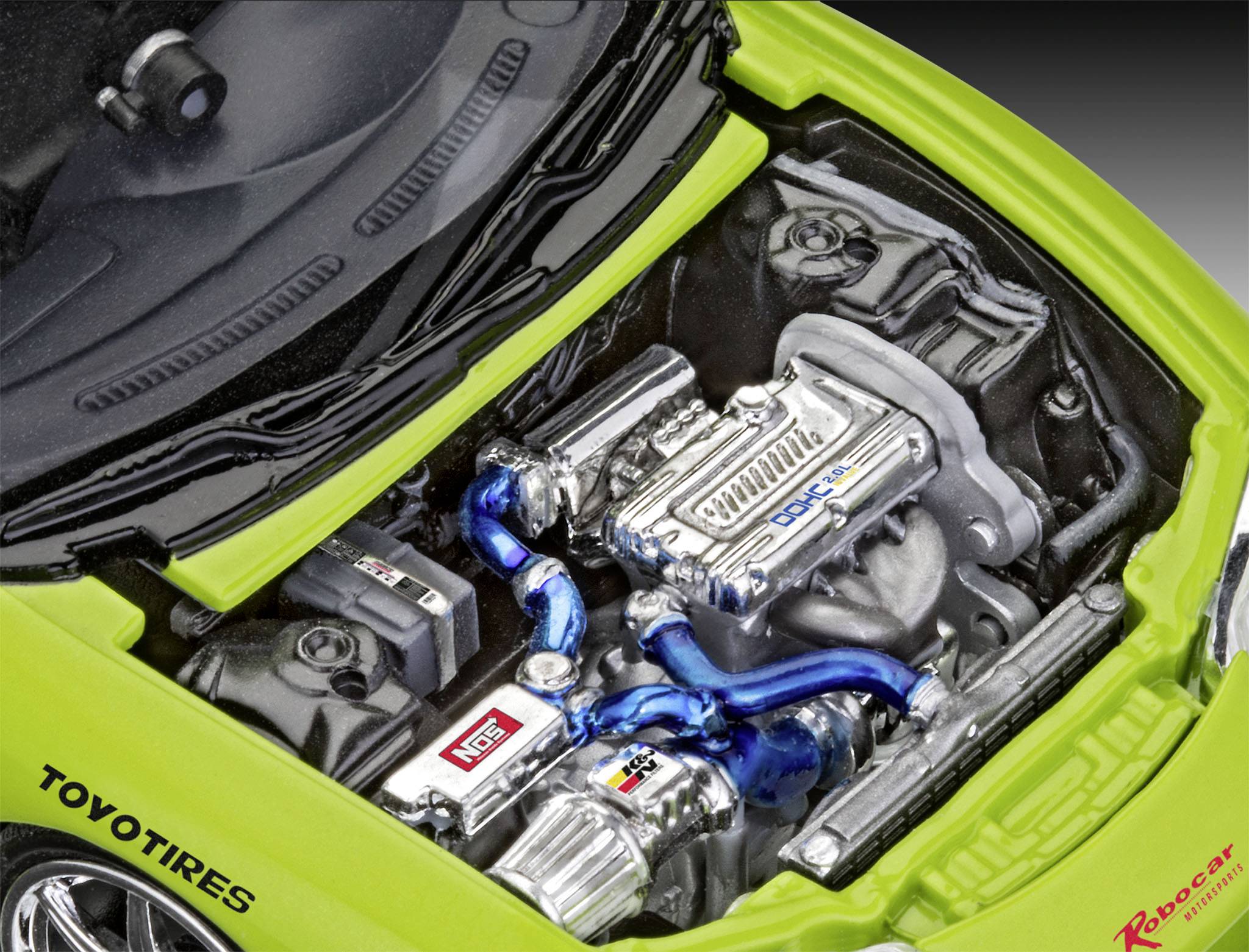 A car with an open bonnet reveals a tuned engine with blue hoses and various brand stickers.
