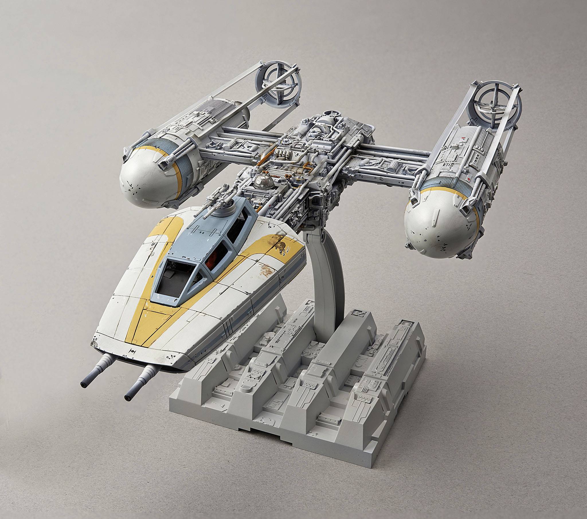 A model spacecraft with two large engines on its sides and yellow markings on the cockpit. It is mounted on a stand.