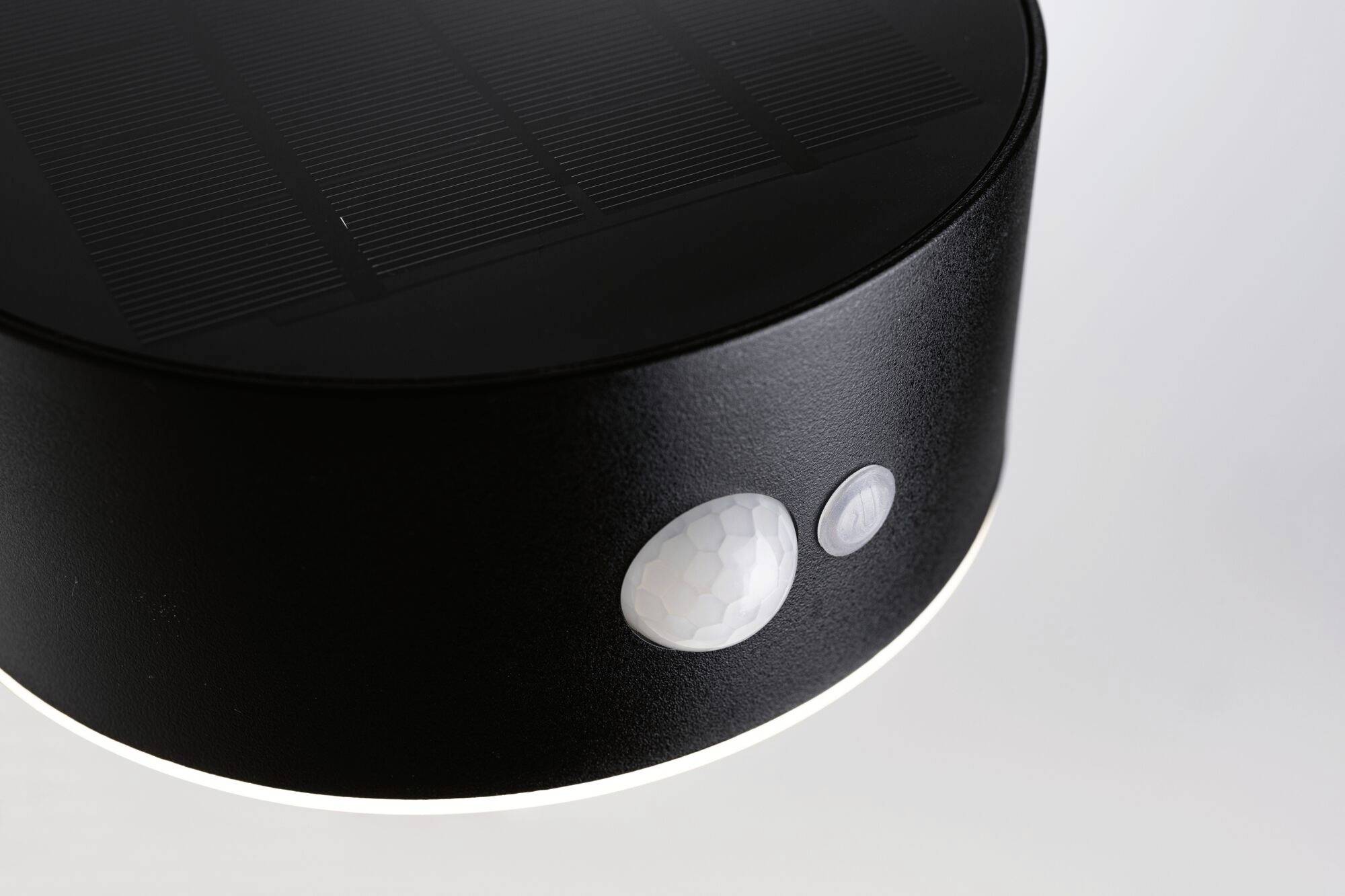 A round, black lamp with two sensors on the front. It is designed for use in darkness.