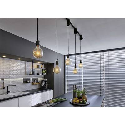 A modern kitchen with hanging light bulbs, a fruit bowl on the island counter and large venetian blinds on the window.