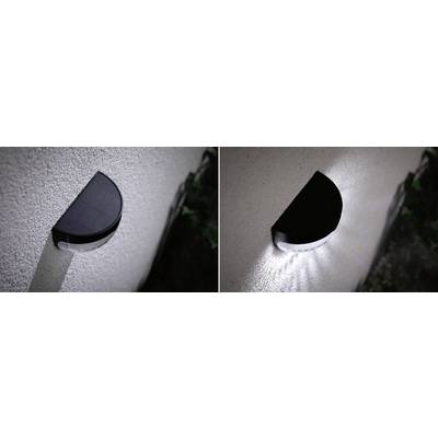 Two images of solar-powered wall lights: one on the left in daylight, the other on the right switched on in darkness, with light pattern directed downwards.