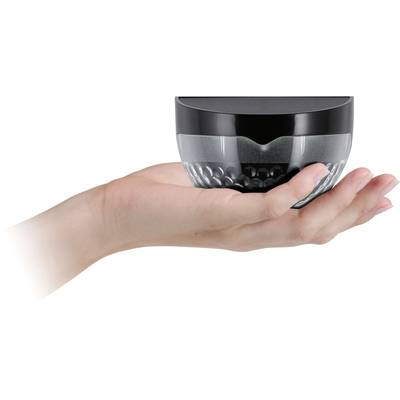 An open hand is holding a small round container with a black lid, which may be used for cosmetic products.