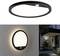 Round LED ceiling and wall light with a black frame. Mounted on the exterior of a house, it illuminates the entrance area.