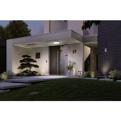 Modern house with illuminated entrance, house number 27, minimalist landscaping and stairs in the background.