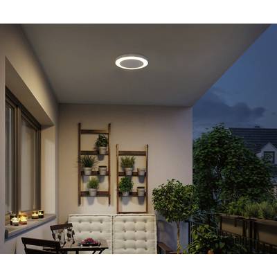 A contemporary balcony setting with wooden furniture. Potted plants hang on a wooden shelf against the wall. A round lamp illuminates the space above.