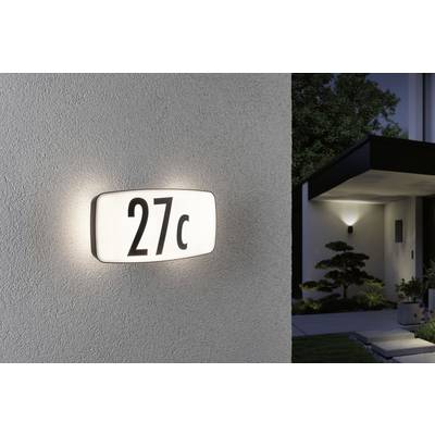 House number '27c' glows on the wall of a modern building, illuminated by a wall light. In the background, a lit entrance area is visible.