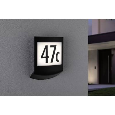 Illuminated house number sign on a grey wall displays '47c'. Background slightly blurred, suggesting a modern building.