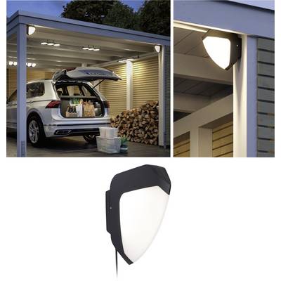 A car is parked in a well-lit, open garage with the boot open. Stacks of wood are placed on the side. Close-up of an attached exterior light.