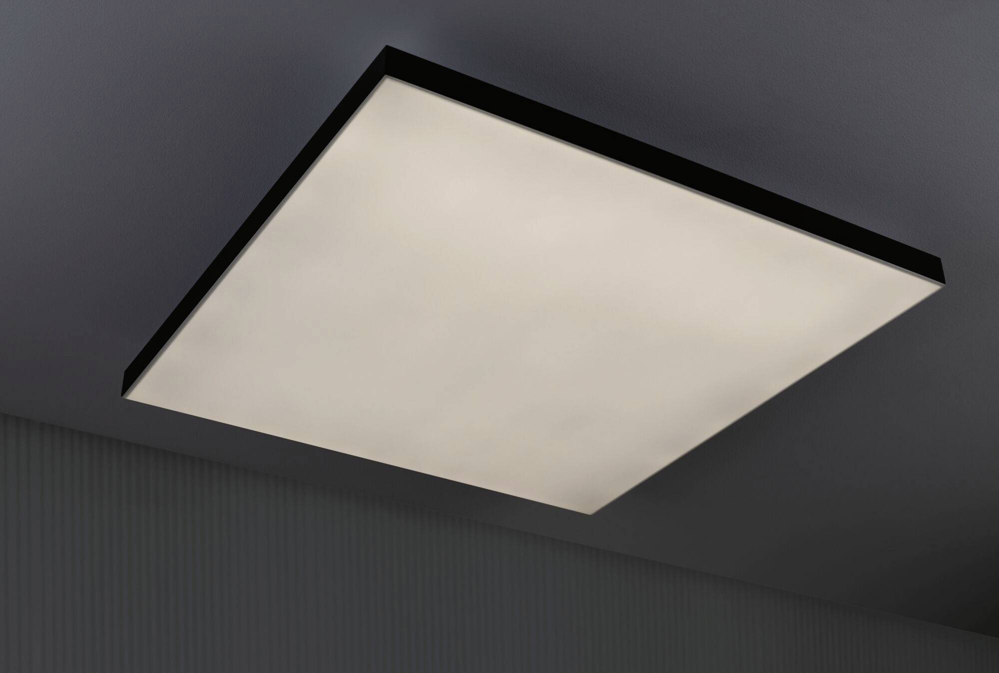 A square ceiling light with diffused white light, mounted on a grey ceiling.