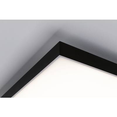 Corner of a room with a modern, black ceiling light emitting a warm white glow. Clean lines and minimalist design.