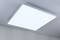 Illuminated LED ceiling panel in a contemporary room, evenly glowing, mounted on a light grey ceiling.