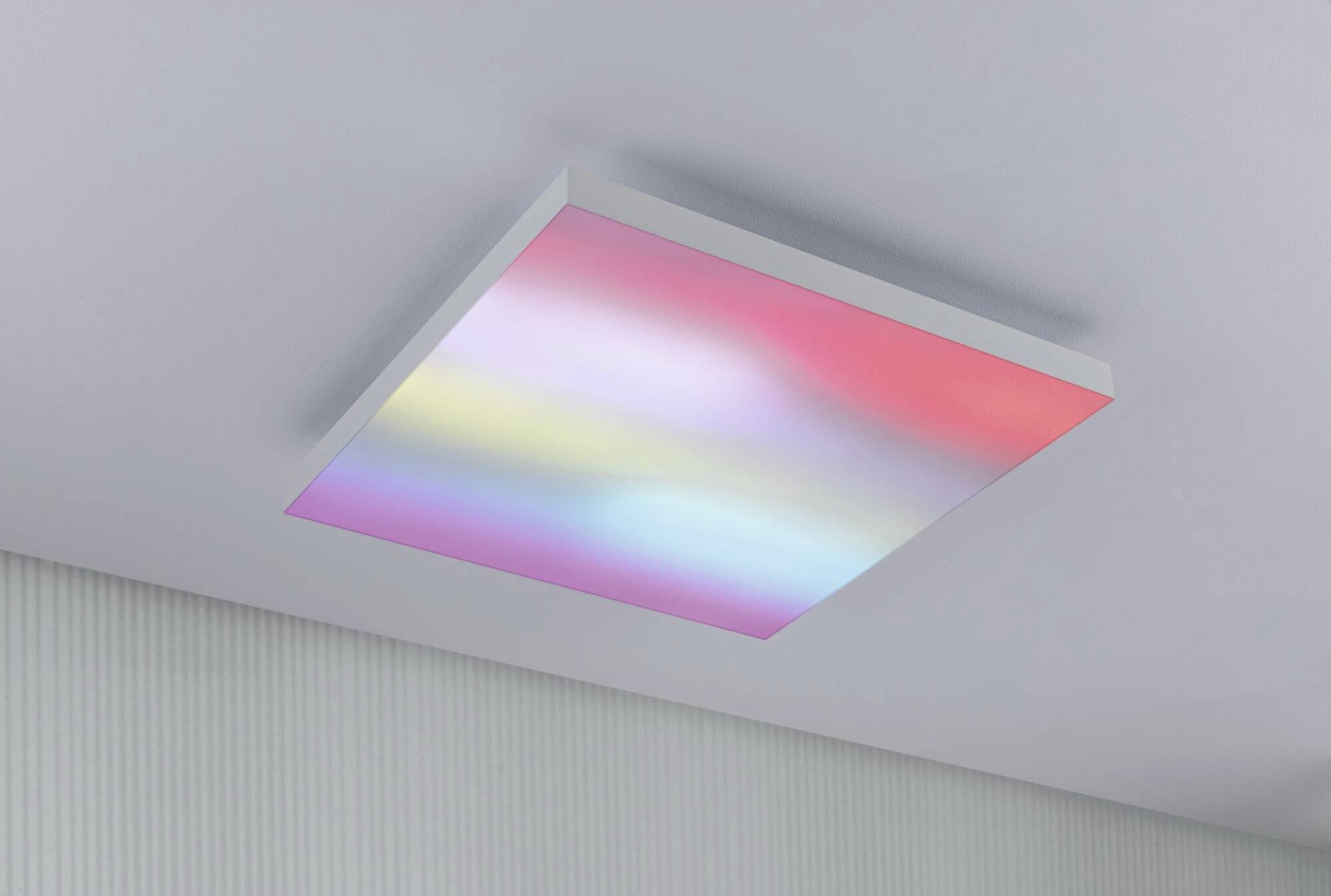 A rectangular ceiling panel with multi-coloured LED lighting, displaying soft colour transitions in red, blue, yellow, and white.