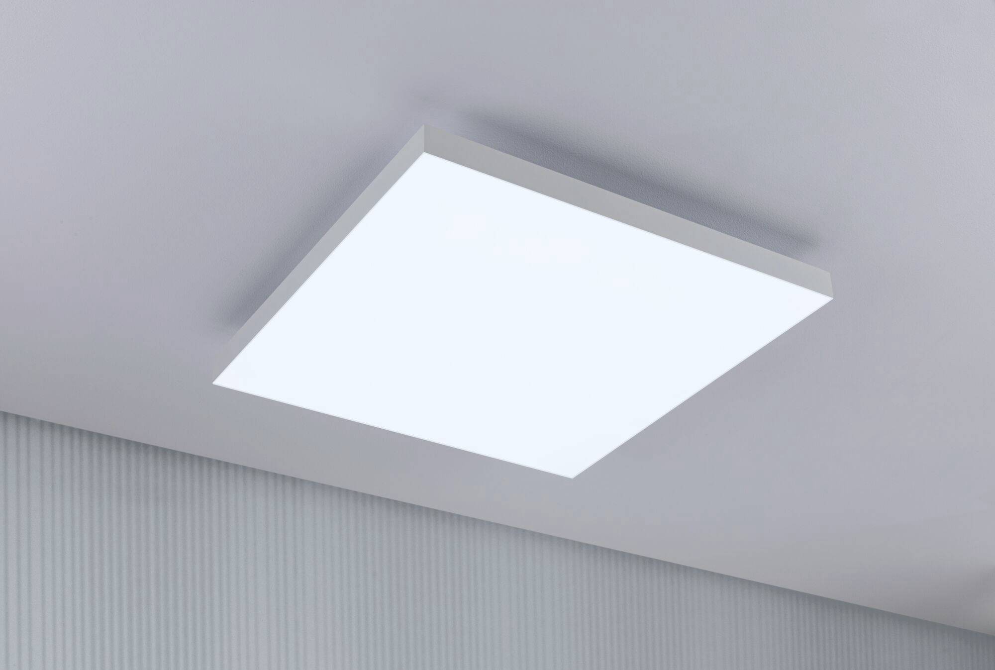 White, rectangular ceiling light mounted on a grey ceiling, providing even illumination of the room.