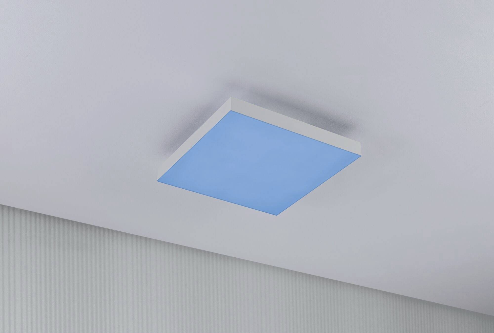 Rectangular ceiling light with blue illumination in a modern room, featuring a simple and clean design.