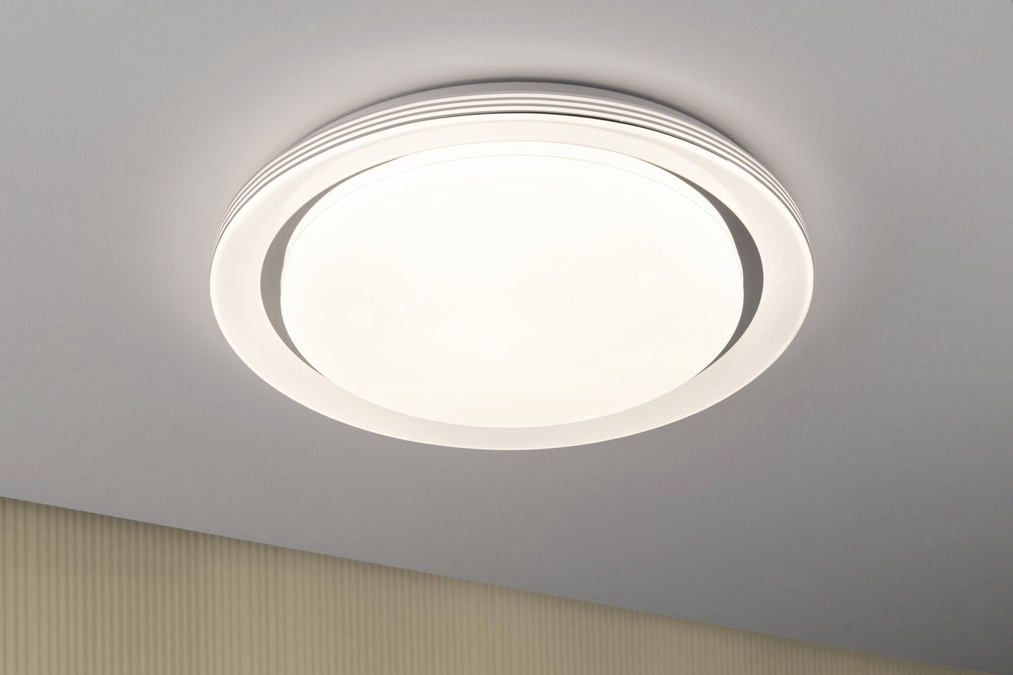Round, modern ceiling light with LED lighting on a bright room ceiling.