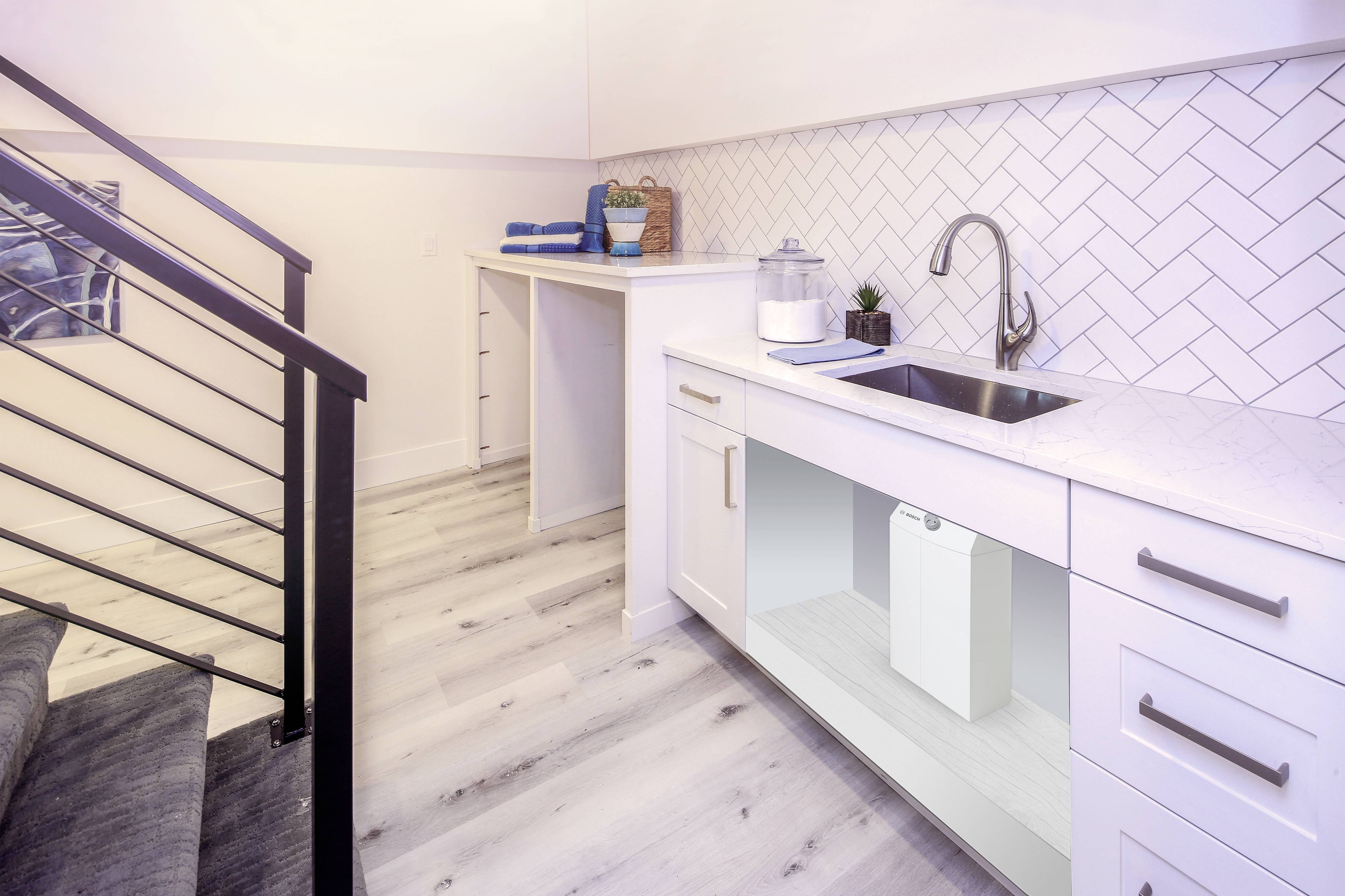 A modern utility room with a white cabinet and washing machine, marble worktop, sink, and decorative elements.