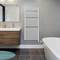 Modern bathroom with a washbasin, mirror, towel radiator, and a freestanding bath.