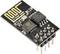 An ESP8266 WiFi module, rectangular with an antenna and pins on one side, serves wireless communication in IoT projects.