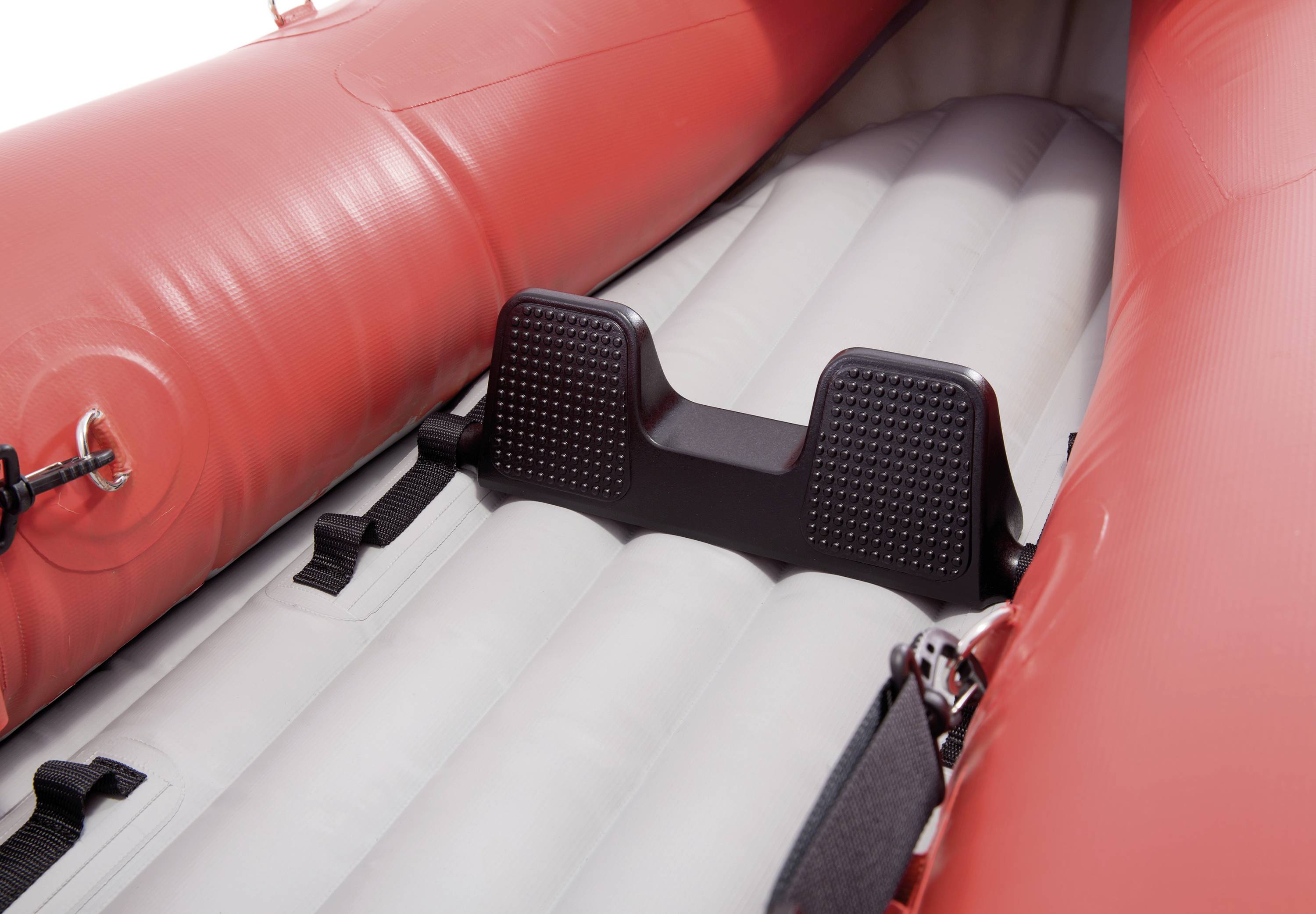 A red inflatable dinghy from the inside, showing part of the seating area and the attachments on the floor.