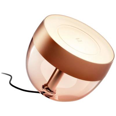 Modern, rose gold table lamp with a round shape and transparent base. It is slightly tilted and has a black power cable.