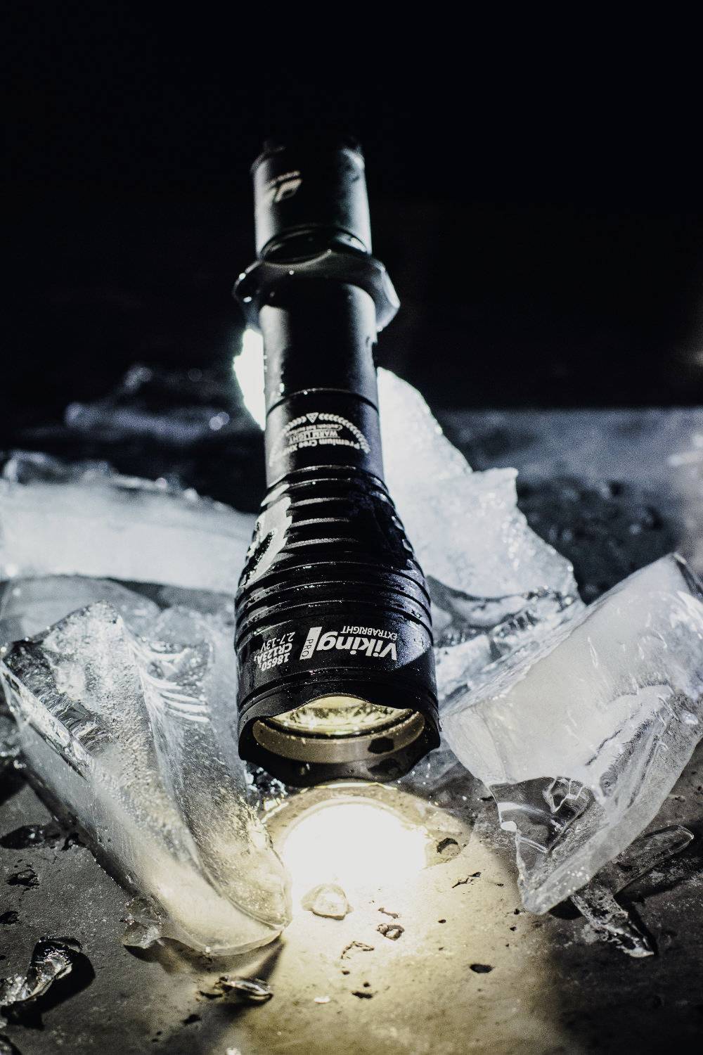 Torch illuminates broken ice in a dark environment. The scene appears dramatic and mysterious.