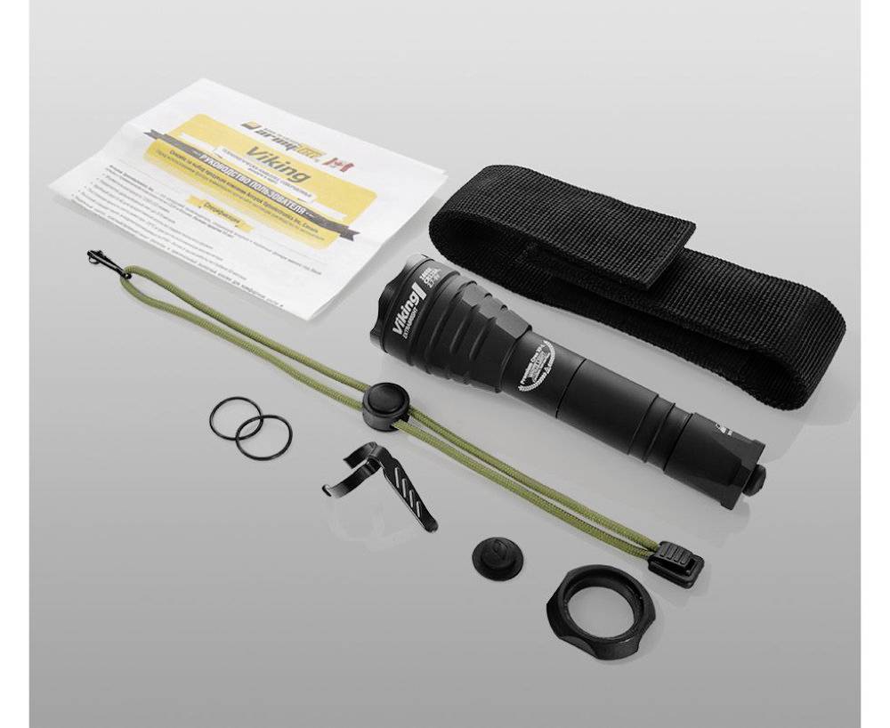 Torch set with instruction manual, carrying loop, belt clip, seals and mounting bracket on a grey background.