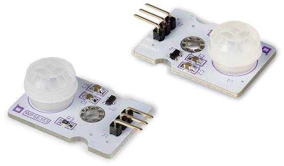 Two electronic infrared sensors on a circuit board with white, hemispherical covers and golden connections.